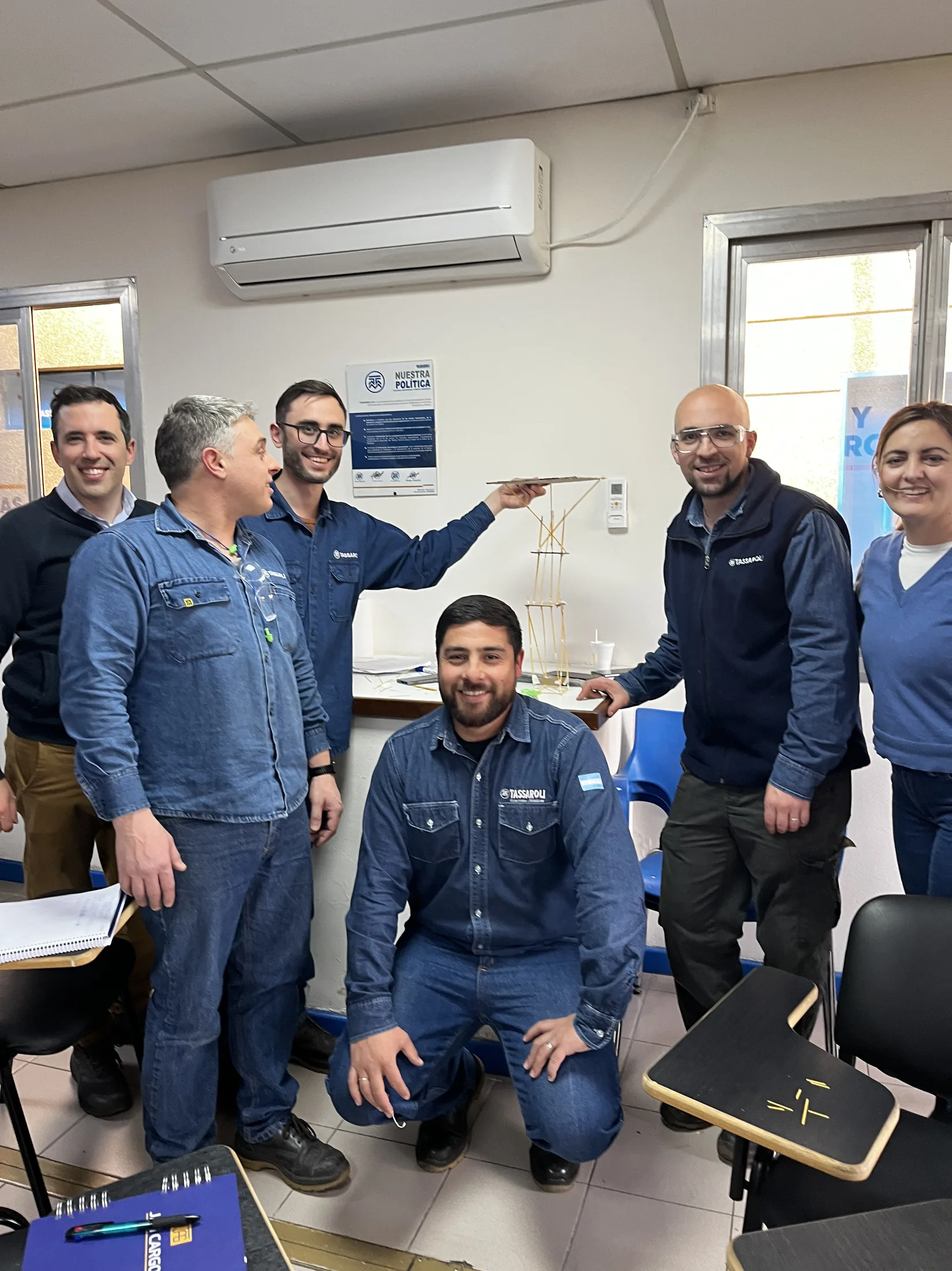 Equipo de Tassaroli sosteniendo la torre que construyeron en equipo